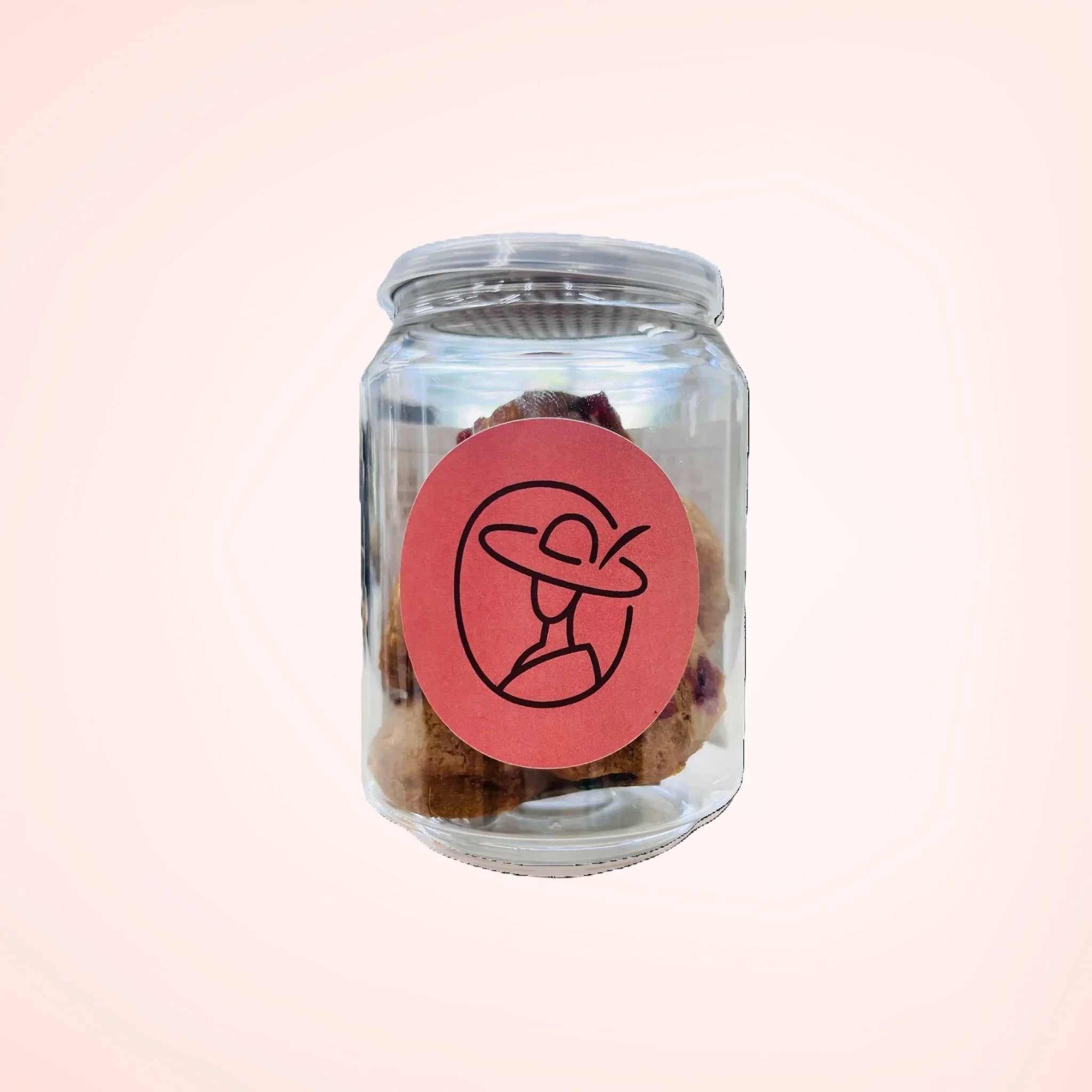クッキー入りの透明な瓶、赤いラベルとシンプルな帽子女性ロゴ付き